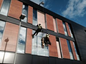 sky access limited workers outside glass windows building