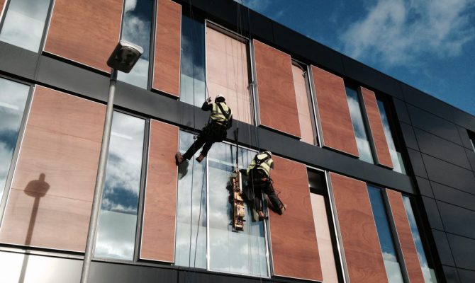sky access limited workers outside glass windows building